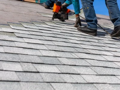 Roofer with a roofing nail gun on job