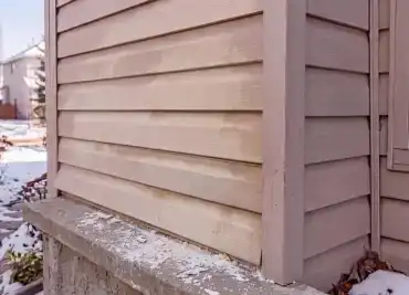 Faded and weathered siding on a Calgary home in need of replacement