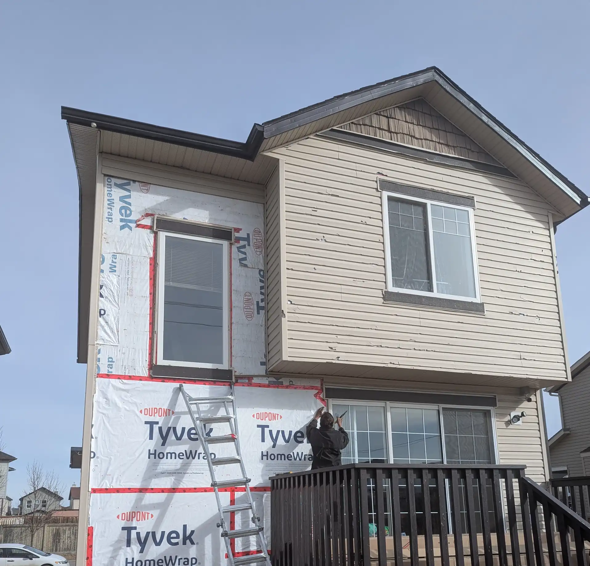 Housewrap installation on a Calgary home exterior by Blueprint Construction before siding replacement