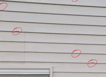 Storm and hail damaged siding on a Calgary home requiring inspection and replacement