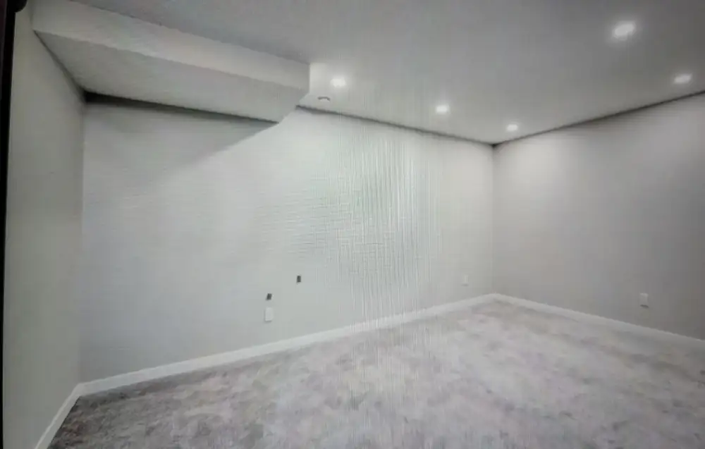 Finished basement room with painted walls, pot lights and new carpet in a Calgary home