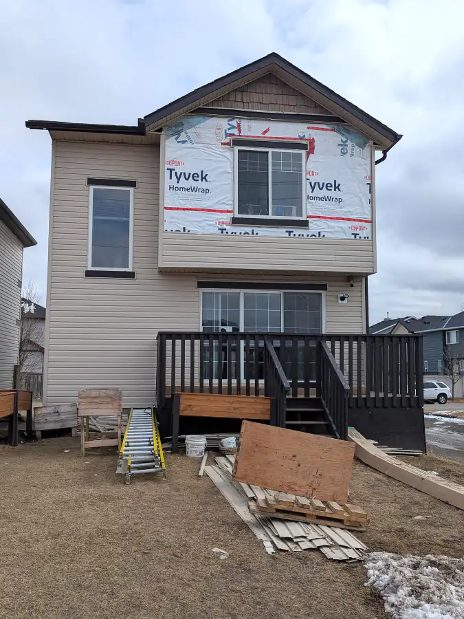 Tyvek house wrap installed on the upper rear wall of a Calgary house with a deck before new vinyl siding went on