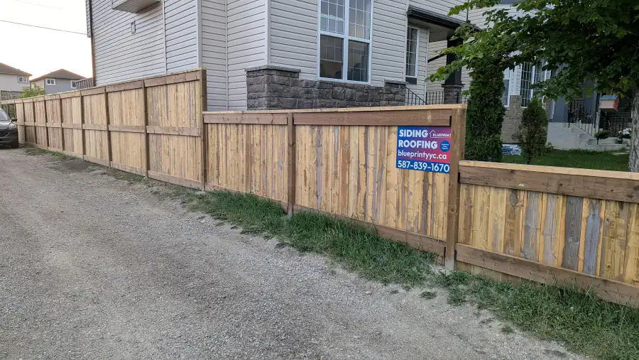 New wood fence boards and rails along a back lane in Calgary during a fence build