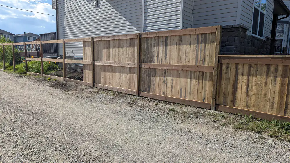 New wood fence with boards, rails and posts along a back lane in Calgary