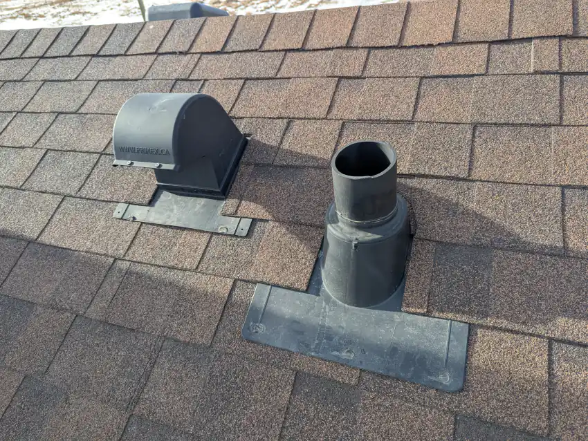 Plastic pipe boot with flashing base and a roof vent on an asphalt shingle roof in Calgary checked during a roof inspection