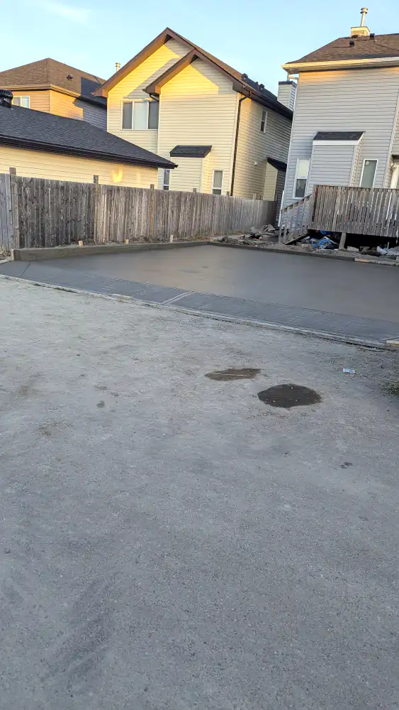 Newly poured and finished concrete pad with control joints behind a Calgary house